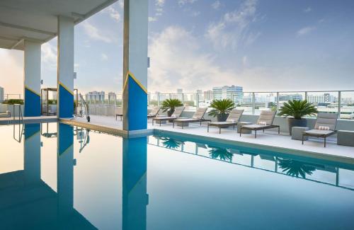 a hotel pool with chairs and a view of the city at SERENA Hotel Aventura Miami, Tapestry Collection by Hilton in Aventura