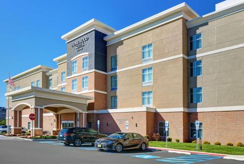 a hotel with two cars parked in a parking lot at Homewood Suites By Hilton Edison Woodbridge, NJ in Edison