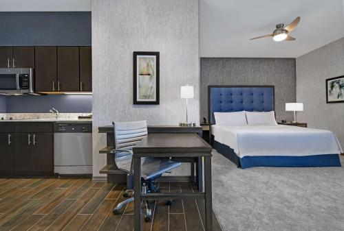 a hotel room with a bed and a desk and a kitchen at Homewood Suites By Hilton Edison Woodbridge, NJ in Edison