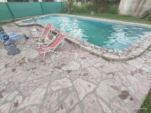 a swimming pool with two lawn chairs next to a swimming pool at Departamentos Don Lucio in La Paz
