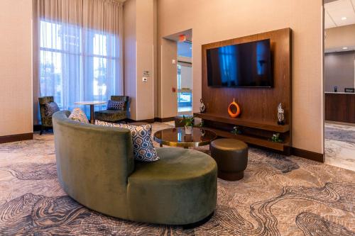 Habitación de hotel con silla y TV en Hampton Inn & Suites Sugar Land, Tx, en Sugar Land