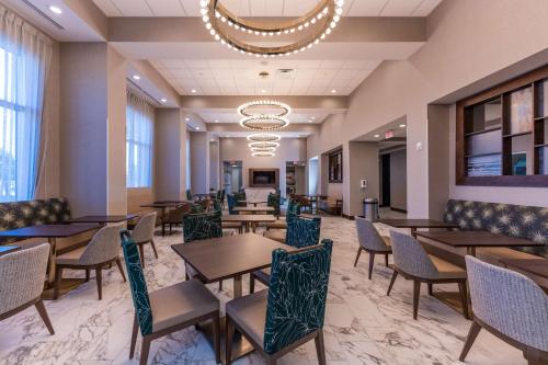 a dining room with tables and chairs and a chandelier at Hampton Inn & Suites Sugar Land, Tx in Sugar Land