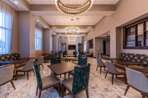 a dining room with tables and chairs and a chandelier at Hampton Inn & Suites Sugar Land, Tx in Sugar Land