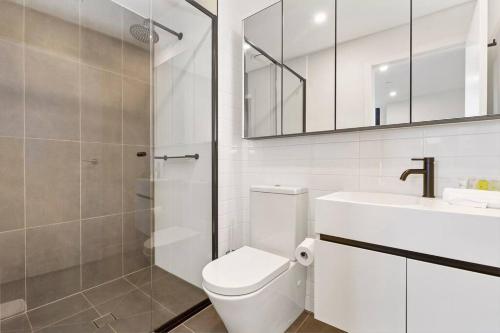 een badkamer met een toilet, een wastafel en een douche bij Breathtaking City & River Views HUGE Balcony! in Melbourne