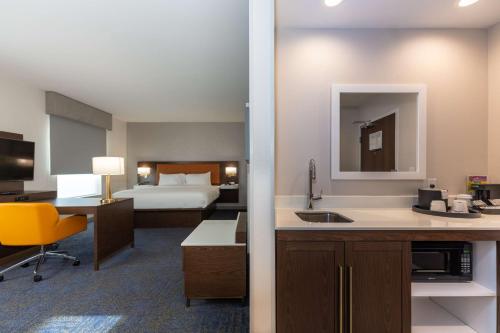 a hotel room with a bed and a kitchen and a bathroom at Hampton Inn & Suites Sugar Land, Tx in Sugar Land