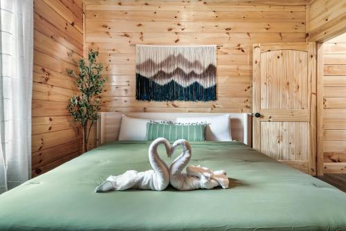 dos cisnes están sentados en una cama en Lykke Lodge, en Pigeon Forge