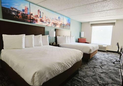 a hotel room with two beds and a window at Best Western Atlanta Cumberland Galleria Hotel in Atlanta