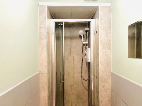 La salle de bains est pourvue d'une douche et d'un téléphone. dans l'établissement Dublin Central Apartment, à Dublin
