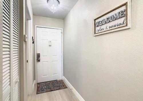 a hallway with a white door and a sign on the wall at Charming Lakeview Retreat III in Orlando