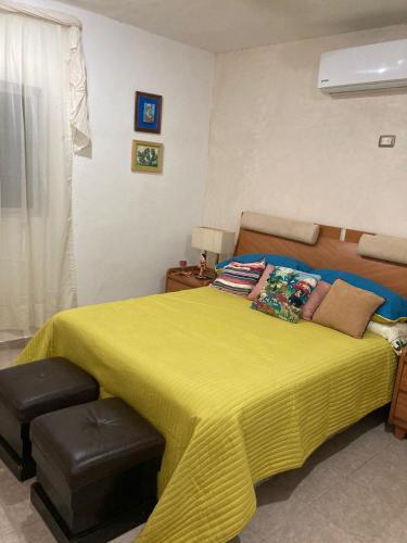 sypialnia z dużym łóżkiem i żółtym kocem w obiekcie Casa Azul w mieście Mérida