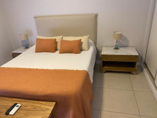a bedroom with a bed and two night stands with lamps at Espacio 20 in Salta