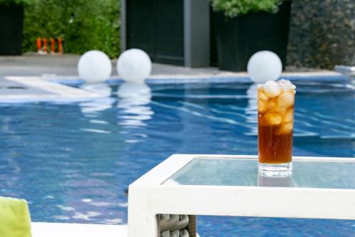a drink sitting on a table next to a swimming pool at Casa Salles Hotel Boutique in Tequila