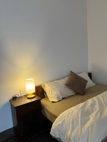 a bedroom with a bed and a lamp on a night stand at Anio Ha Giang Hotel in Ha Giang