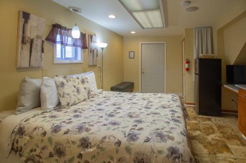 a bedroom with a bed with a flowered comforter at Stay In Ohiopyle in the middle of town by the GAP trail in Farmington