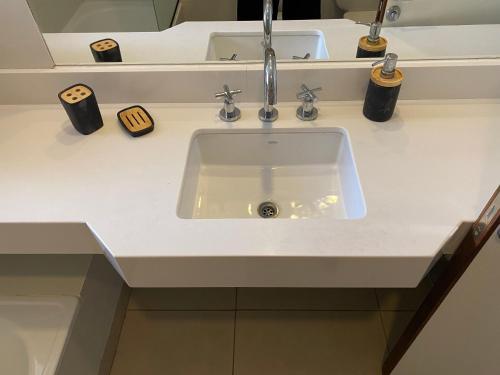 lavabo blanco en un baño con 2 tazas en Espacio 20, en Salta