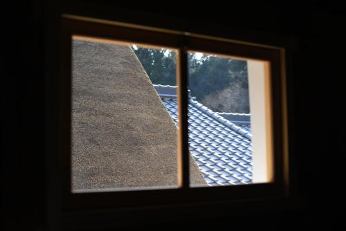 a view through a window of a roof at うだ薬湯の宿やたきや in Uda