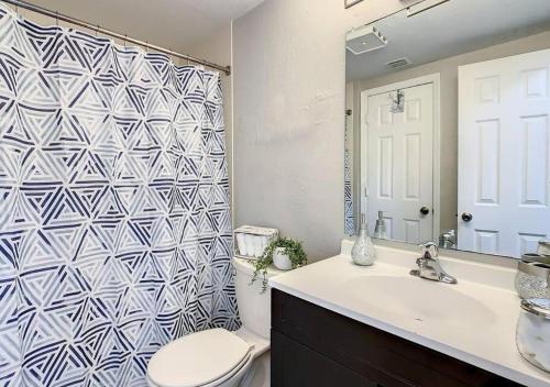 a bathroom with a toilet and a sink and a mirror at Charming Lakeview Retreat in Orlando