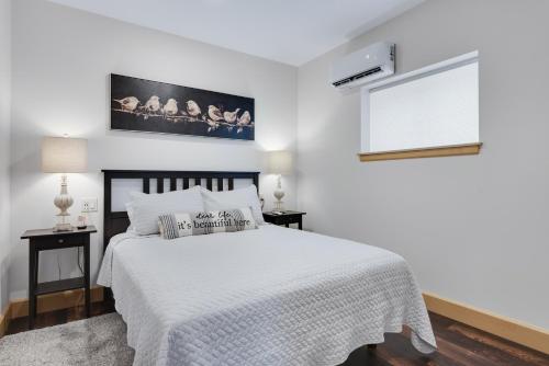 um quarto branco com uma cama com um edredão branco em Magnolia Suite - Main Street Lodge in Berlin em Berlin