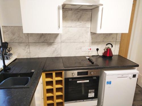 a kitchen with a sink and a stove top oven at Park Lane Ground Floor Apartment - Workington Town Centre in Workington