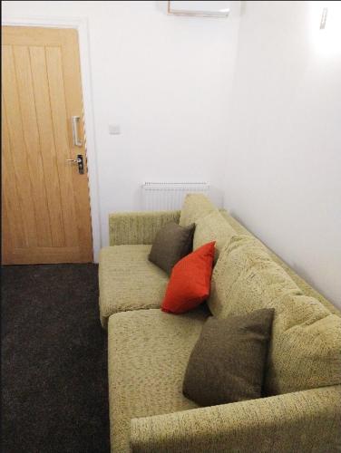 - un canapé avec trois oreillers dans l'établissement Park Lane Ground Floor Apartment - Workington Town Centre, à Workington
