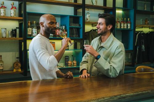 two men sitting at a bar drinking wine at Casa Salles Hotel Boutique in Tequila