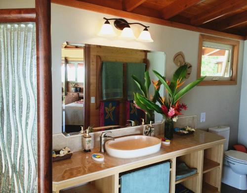 Exclusive Sunrise Eco Resort في Saraotou: حمام مع حوض ومرآة كبيرة