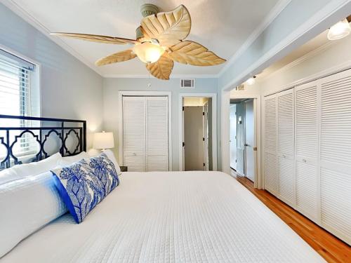 een slaapkamer met een bed en een plafondventilator bij Beach Racquet A301 in Tybee Island