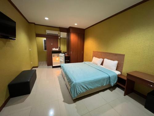 1 dormitorio con 1 cama y TV en จินตคามโฮมเพลส/Jintakam Home Place, en Udon Thani