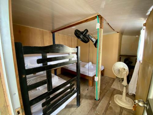 a small room with two bunk beds and a fan at Eco Hostal Estrella De Mar in Isla Mucura