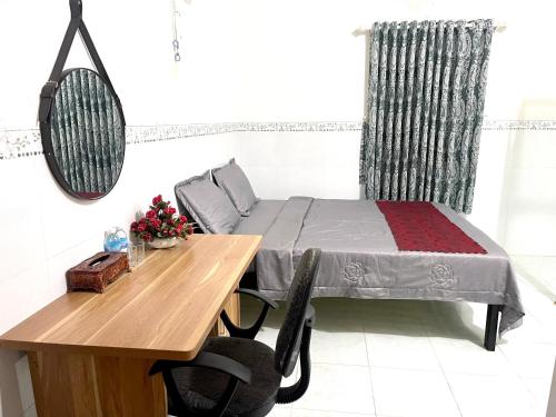 Schlafzimmer mit einem Bett, einem Tisch und einem Spiegel in der Unterkunft Motel An Bình in Dien Khanh