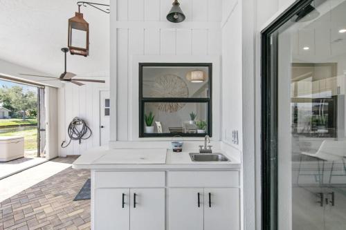 eine weiße Küche mit einem Waschbecken und einem Spiegel in der Unterkunft Waterside Villa Fish Swim Golf Enjoy in Rotunda-West