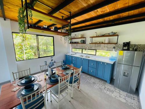 a kitchen with blue cabinets and a table with chairs at Chega de Saudade in Puerto Quito