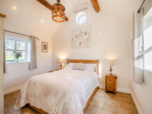 a bedroom with a bed and a window at Bank House Barn in Audlem