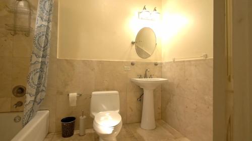a bathroom with a toilet and a sink and a mirror at Royal Palms Estate in Christiansted