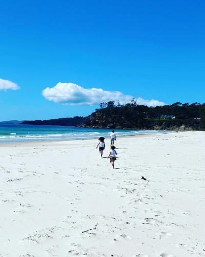 a group of three people walking on a beach at Spring Beach Retreat in Spring Beach