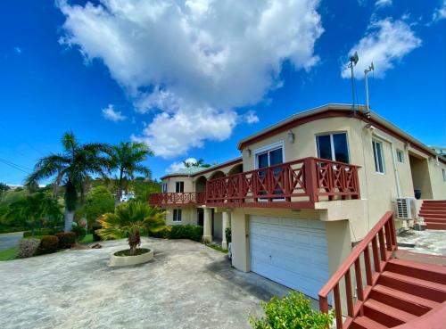 a house with a balcony and a driveway at Royal Palms Estate in Christiansted