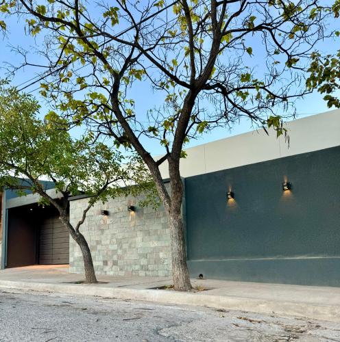 a building with two trees in front of it at Casa Del Cable Carril in Chilecito
