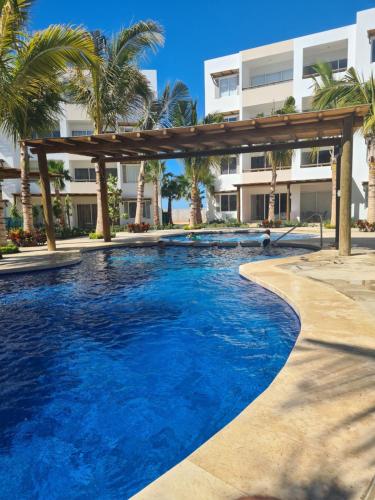 una piscina con pérgola frente a un edificio en Departamento Vacacional en Mazatlán, en Mazatlán