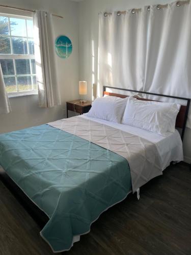 ein Schlafzimmer mit einem großen Bett mit einer blauen Decke in der Unterkunft John’s Place in Grand Turk