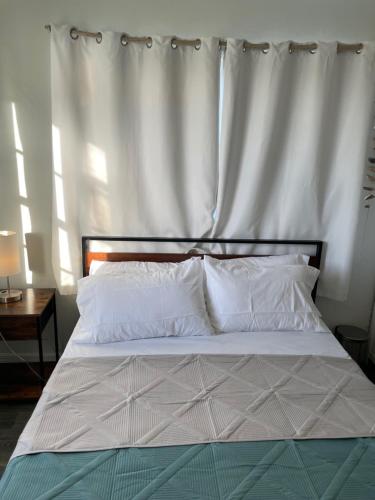 a bed with white sheets and pillows in a bedroom at John’s Place in Grand Turk