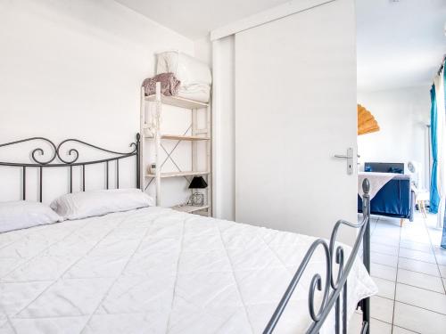 um quarto branco com uma cama e uma prateleira em Appartement Biscarrosse, 2 pièces, 3 personnes - FR-1-521-217 em Biscarrosse