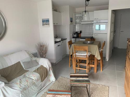 Il comprend un salon et une cuisine avec une table et un canapé. dans l'établissement Fort-Mahon-Plage: À deux pas de la plage, appartement neuf avec balcon et garage - FR-1-482-134, à Fort-Mahon-Plage