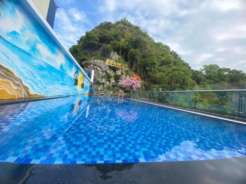 una piscina en la azotea de un hotel con una montaña en KIÊN NGỌC VILLA Cat Ba, en Cat Ba