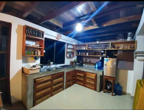 a large kitchen with wooden cabinets and a stove at Casa Campestre in Bocas del Toro
