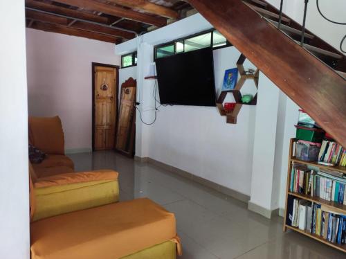 a living room with a tv and a book shelf at Casa Campestre in Bocas del Toro