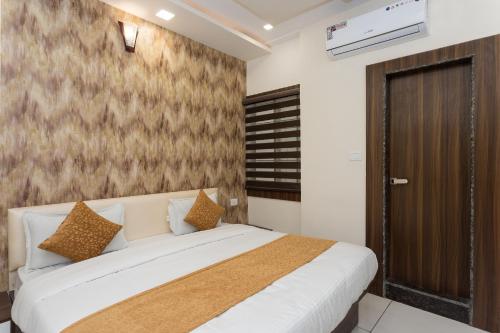 ein Schlafzimmer mit einem Bett und einer braunen und weißen Wand in der Unterkunft OYO Flagship Hotel Shri Vilas in Bhopal
