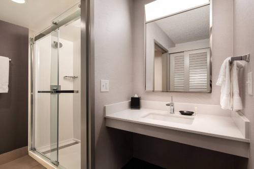 uma casa de banho com um lavatório e um chuveiro em Courtyard by Marriott Fresno em Fresno