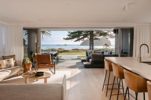 an open kitchen and living room with a view of the ocean at 36 Marine - Unparalleled beachfront luxury in Mount Maunganui