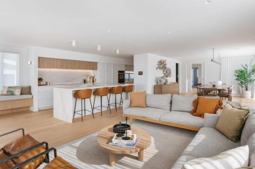 a living room and kitchen with a couch and a table at 36 Marine - Unparalleled beachfront luxury in Mount Maunganui