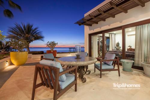 a patio with a table and chairs and the ocean at Playa de La Paz 3 BR Condo Access to Beach club in La Paz